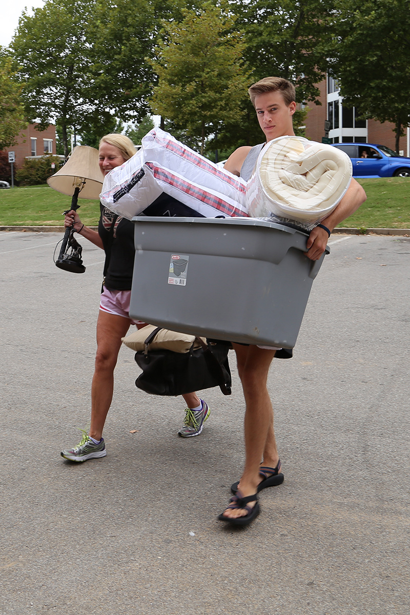 Students haul bins and accessories into Futrall Hall.