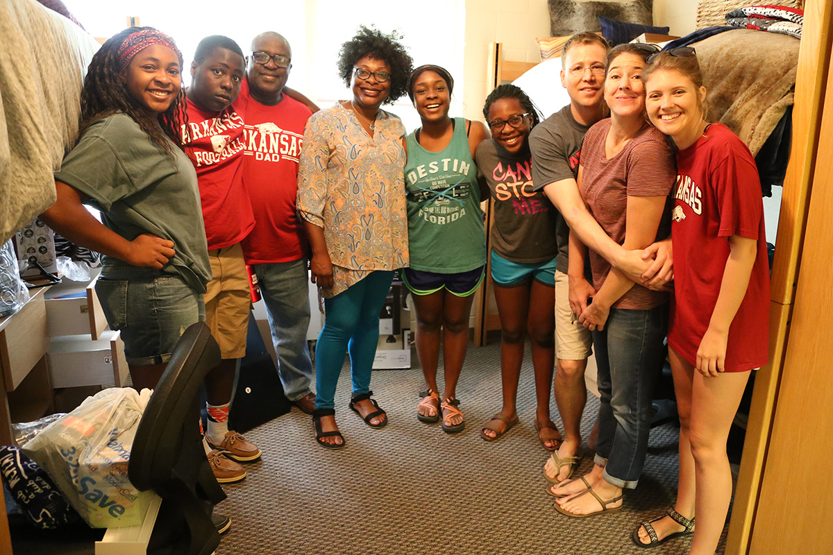 Blossom Amechi (center) and Brett Caraway (right) gather with their families in their room in Buchanan-Droke.